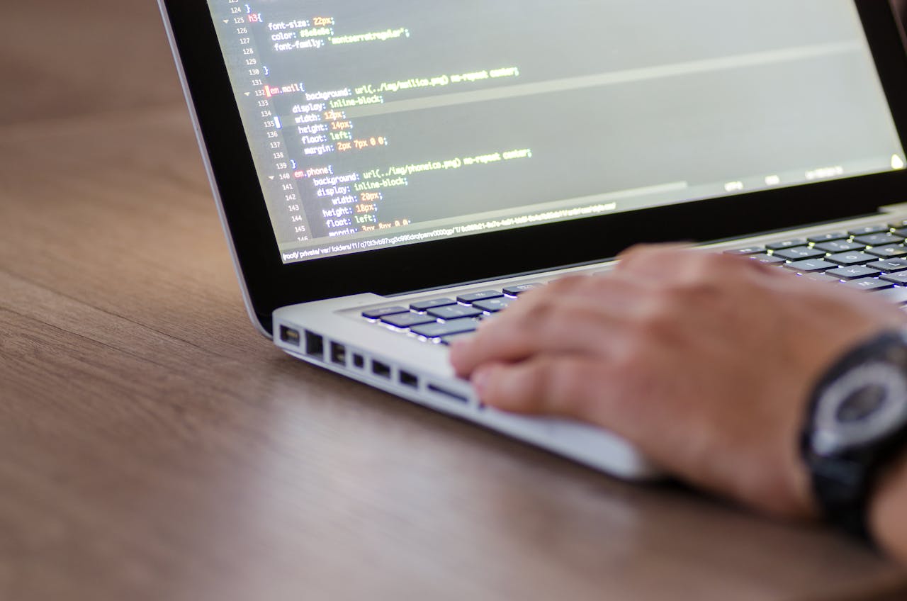why-choose-us Person coding on a laptop with HTML code on screen, showcasing development work.