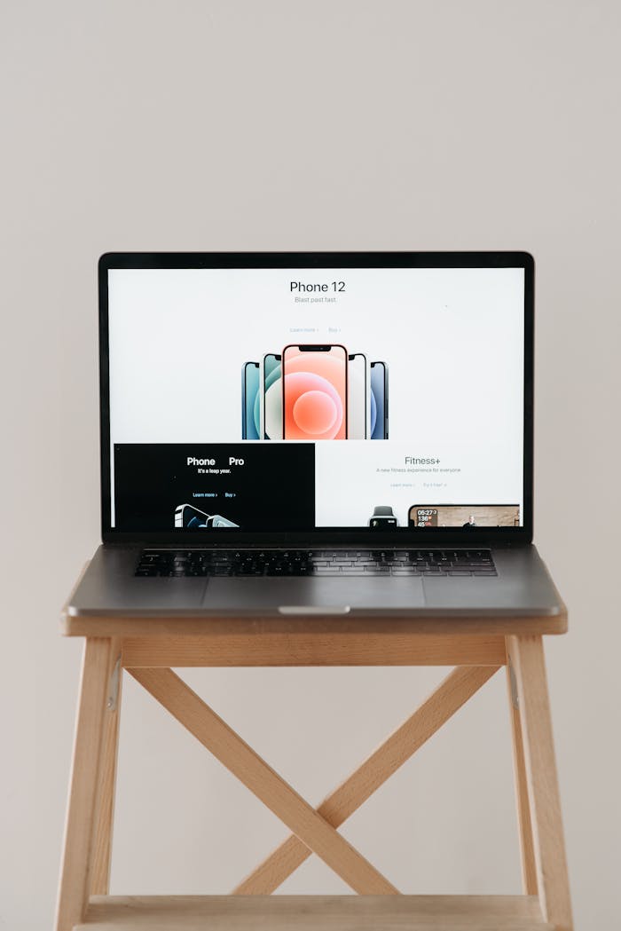 creative A sleek laptop on a wooden table showing a smartphone advertisement, perfect for tech and gadget content.